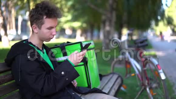 送货的人带着绿色的背包和自行车正在寻找客户电话地址视频的预览图