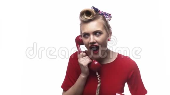 美丽发型的金发女郎正在她的旧电话上讲话慢动作视频的预览图