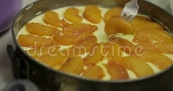 把桃子放在混合的干酪和鸡蛋上芝士蛋糕视频的预览图