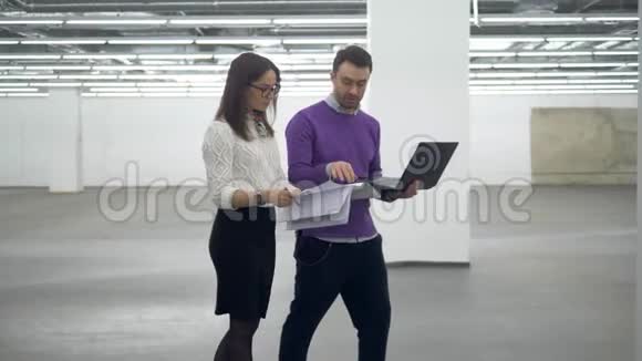 工程师们在一个设施里行走用笔记本电脑和文件工作视频的预览图