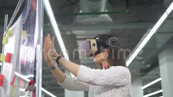 一位女士戴着虚拟现实眼镜在一块板上从事工程项目视频的预览图