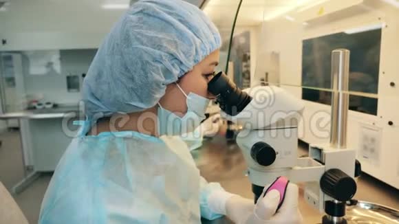 女性实验室专家正在研究显微镜视频的预览图