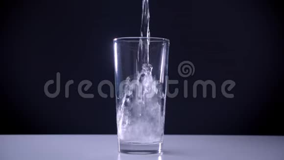 白色桌子上的透明玻璃的特写镜头碳酸水被用孤立的水浇进去视频的预览图