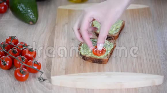 纯素三明治与鳄梨和蔬菜在切割板木制背景视频的预览图