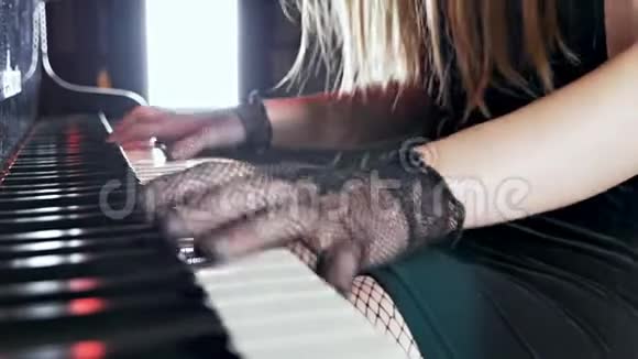 紧紧抓住一位戴着钢琴手套的性感女钢琴家的手视频的预览图