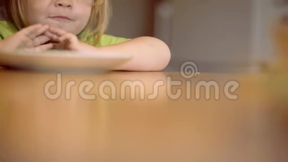 笑着可爱的小男孩坐在高椅上在厨房的背景下吃东西为人父母美丽的肖像视频的预览图