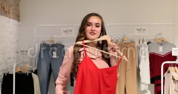 年轻女子在商店里穿着衣服视频的预览图