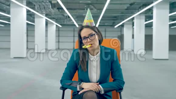 一个戴生日帽的上班族吹口哨坐在椅子上视频的预览图