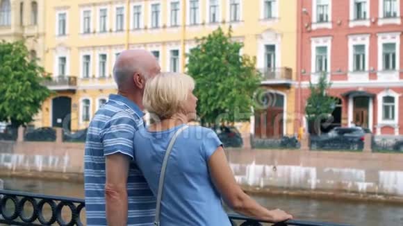 老两口站在运河码头四处张望养老金领取者在俄罗斯圣彼得堡旅行视频的预览图
