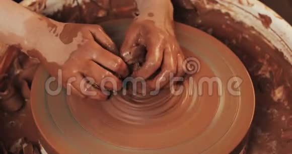 手在陶轮上工作在粘土板上形成浮雕波特在工作关门手工制作工艺红色粘土视频的预览图