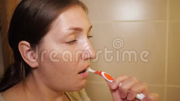 年轻的女人正在刷牙视频的预览图