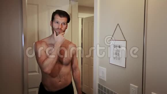 英俊的白种人年轻男子看着自己在浴室镜子欣赏他的胡子与他可爱的女朋友视频的预览图