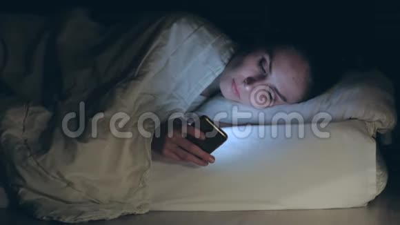 女人躺在床上睡着了放下并关掉智能手机视频的预览图