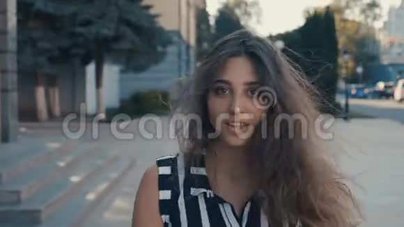 年轻漂亮的女人走在城市里转身微笑摄像机跟在后面视频的预览图