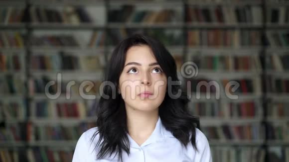 图书馆书架背景上女孩的特写照片视频的预览图