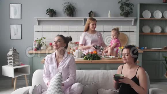 三个女人和孩子早上坐在厨房里视频的预览图