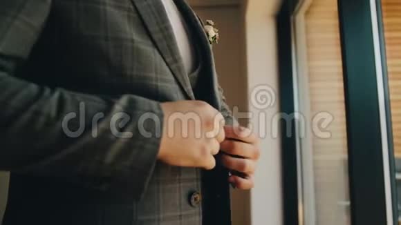 时髦的男人把夹克的扣子系在一扇明亮的大窗户前从窗户发出美丽的光关闭视频的预览图