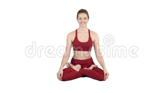 年轻微笑的女人练习瑜伽做帕德马萨纳运动莲花姿势在白色背景上视频的预览图