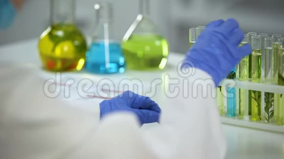 生物化学家比较试管中的植物与绿色和蓝色液体防腐剂视频的预览图
