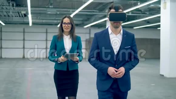 两个房地产经纪人在房间里散步时使用VR眼镜视频的预览图