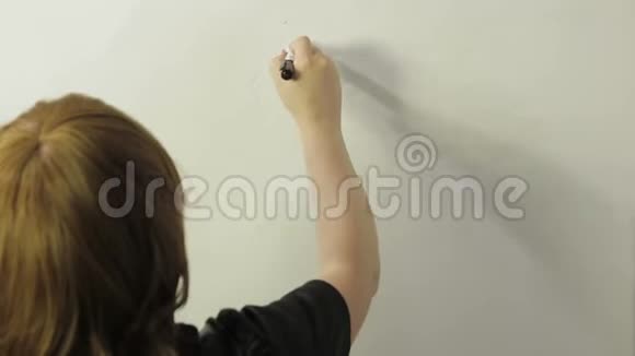 一个女人背着她站着在白板上画一个货币和图形的符号时光飞逝视频的预览图
