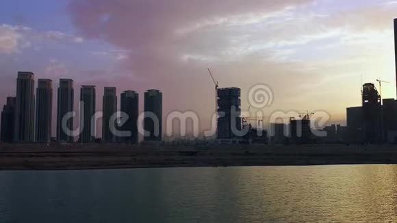 日落时分阿布扎比阿尔里姆岛AlReemIsland城市现代化摩天大楼和海滨工作区的景观视频的预览图