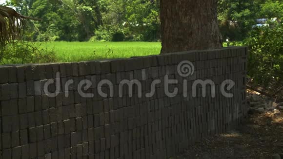 绿色田野周围的砖篱笆视频的预览图