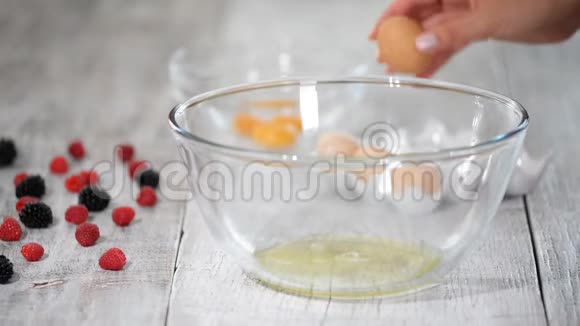 雌性的手把蛋清和蛋黄分开放在厨房的碗里视频的预览图