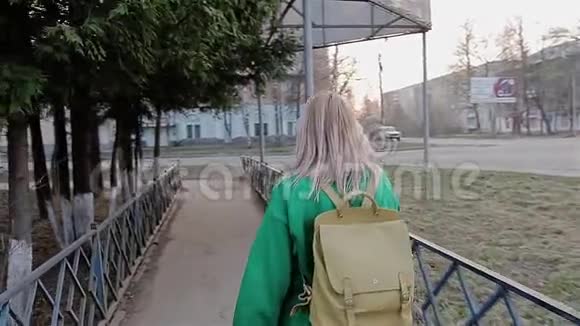 女孩被抱在城市里的一棵树枝下试图把手伸进这个动作中她跳起来视频的预览图