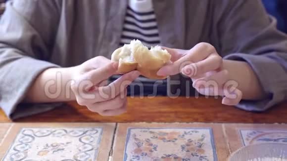 在澳门葡萄牙人休息的时候一个被裁剪的女人正在用手把一个美味的面包撕成碎片吃着开胃菜视频的预览图