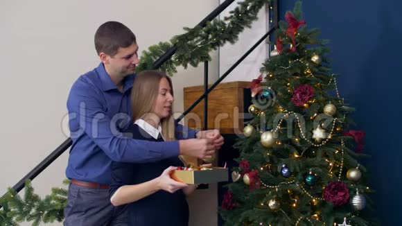 夫妇用装饰品装饰圣诞树视频的预览图