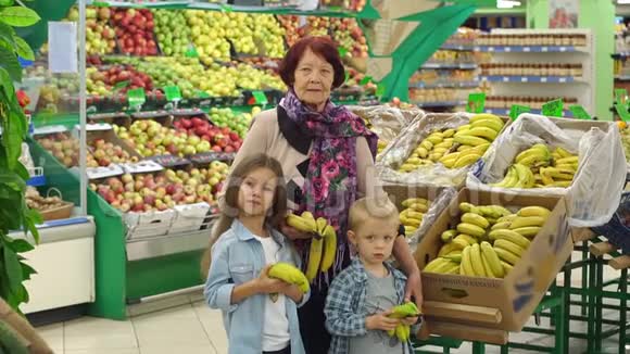 奶奶和孙子在店里买香蕉慢动作视频的预览图