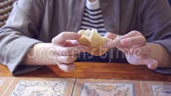 在澳门葡萄牙人休息的时候一个被裁剪的女人正在用手把一个美味的面包撕成碎片吃着开胃菜视频的预览图