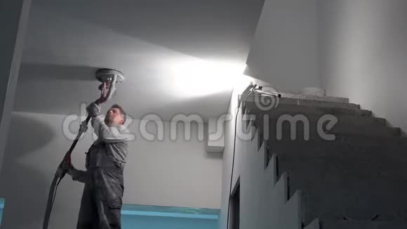 肮脏的泥塑工人用砂光机打磨天花板房屋翻新工程视频的预览图