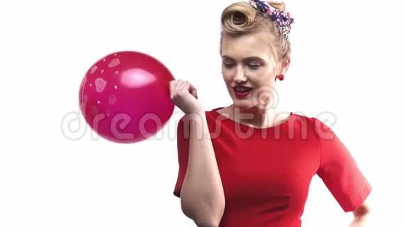 笑着笑着穿着红色衣服的可爱金发女人正拿着气球慢动作视频的预览图