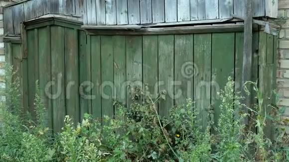 关闭草盖的门或灯芯在木材绿色围栏在农村废弃的大门乡村景色无人居住视频的预览图