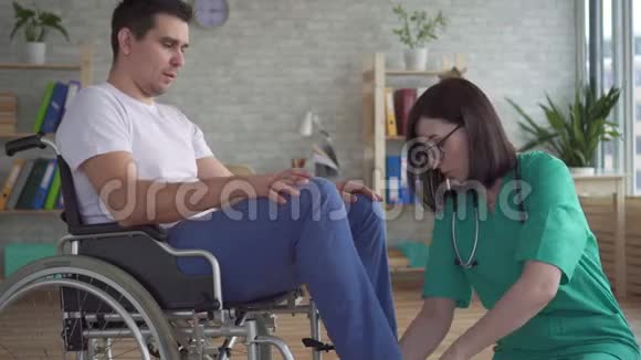 医生近距离检查轮椅上残疾人的腿部视频的预览图