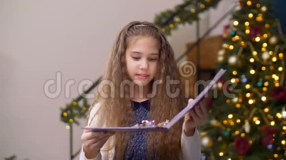 可爱的女孩吹着书上闪闪发光的五彩纸屑视频的预览图