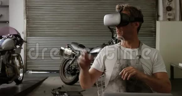 男机修工在摩托车修理厂4k中使用虚拟现实耳机视频的预览图