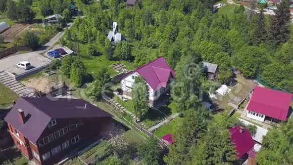 从雄蜂号上可以看到一个美丽的小村庄里面有现代化的农舍和绿树削减夏季乡村鸟瞰图视频的预览图