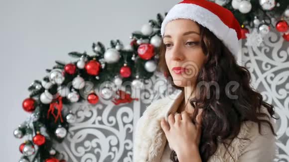 圣诞老人戴着一顶漂亮深黑的帽子站在她面前站在圣诞节的背景下显得很体贴视频的预览图