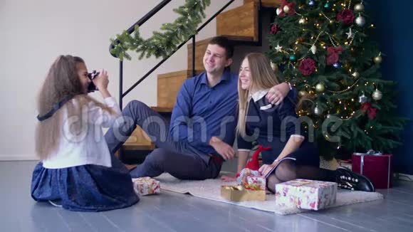 女孩在圣诞节给她快乐的父母拍照视频的预览图