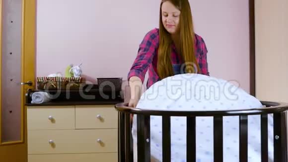 一名年轻孕妇为新生儿做准备折叠儿童木制的视频的预览图