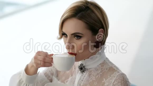 穿着白色衬衫喝咖啡的迷人商务女性视频的预览图