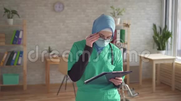 一位女医生的特写照片是一位带文件夹的穆斯林妇女视频的预览图
