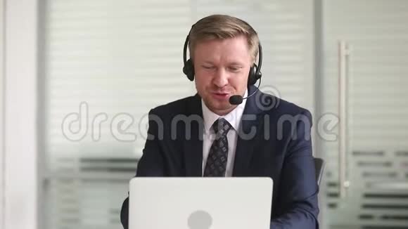 戴耳机说话的商人在手提电脑上打视频电话视频的预览图