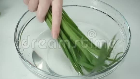 女人手葱慢动作女人的手在一杯水中洗了一串洋葱视频的预览图