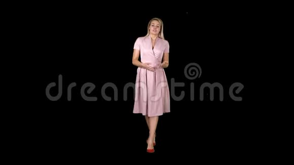 快乐的年轻女子穿着粉色连衣裙走向镜头交谈阿尔法频道视频的预览图