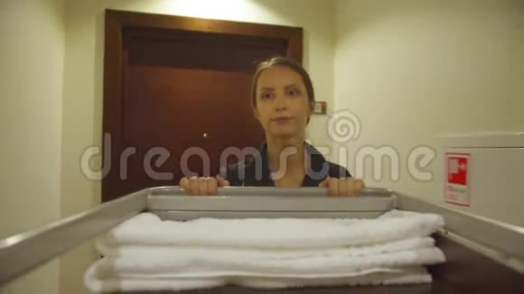 客房服务员带着清洁设备穿过酒店走廊视频的预览图