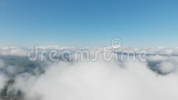 鸟瞰全景白天飞行在阳光明媚的一天飞越云层和山上的概念视频的预览图